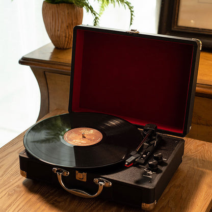 Vintage-style portable Auryvox Heritage VT-80 Portable Turntable on a wooden surface with a plant in the background