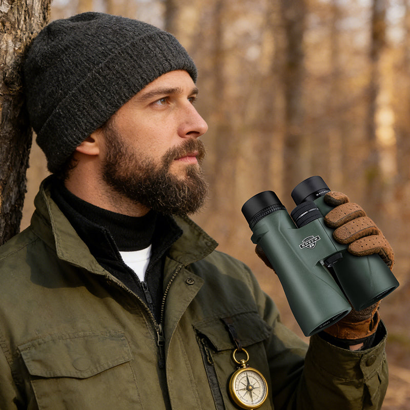 Man in outdoor gear holding Bosco Apex HD-X1 Binoculars in a forest setting