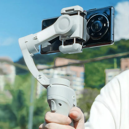 Hand holding a smartphone Bytech Gimbal with a clear sky and blurred background