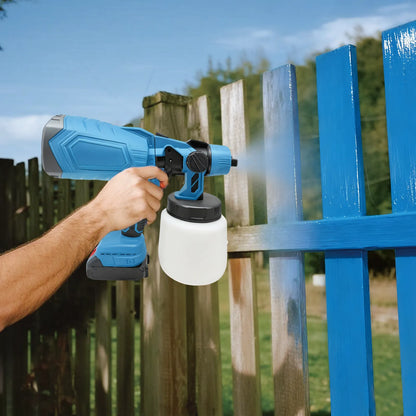 Person using a blue Calthic Cordless Paint Sprayer to paint a wooden fence.