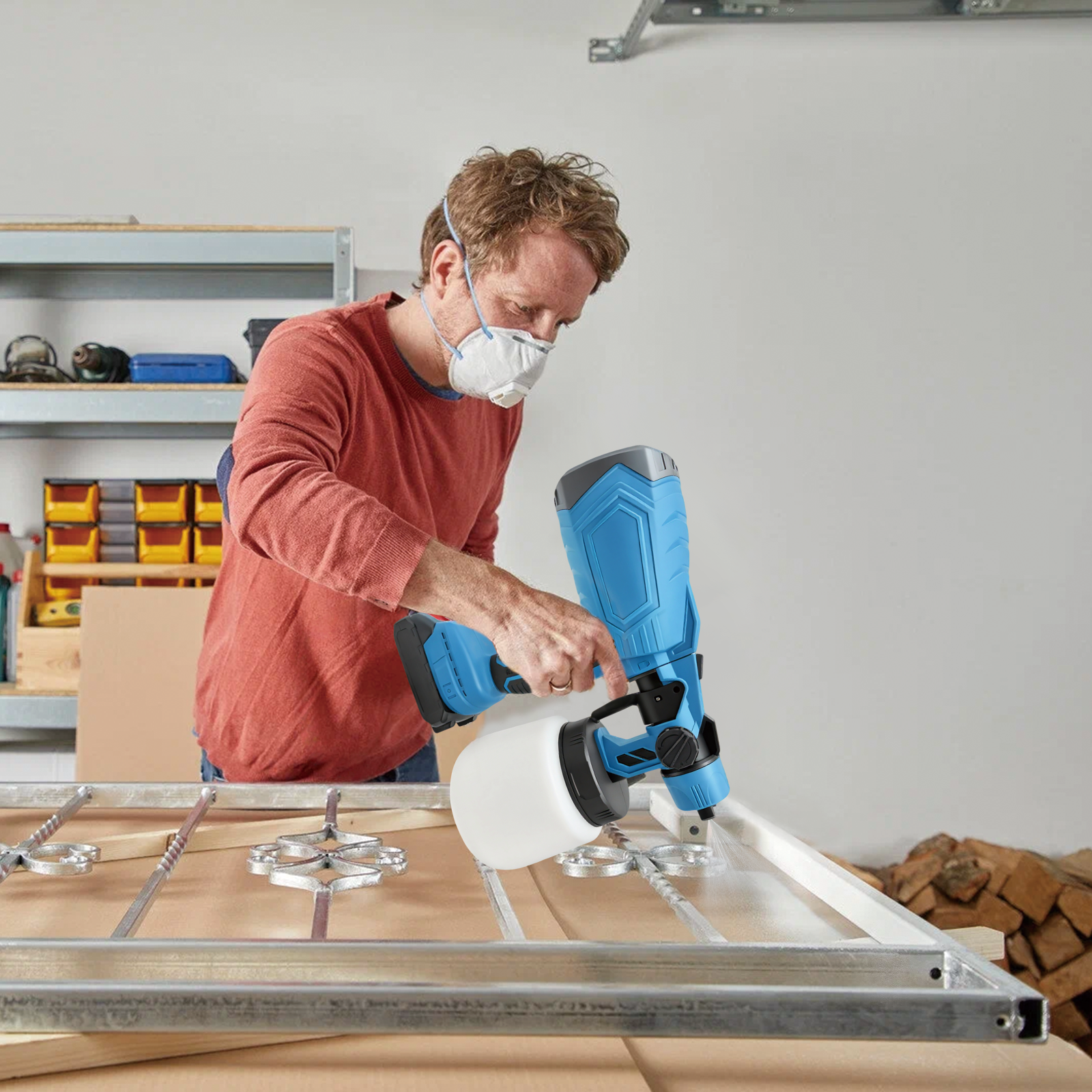 Man using a Calthic Cordless Paint Sprayer on a wooden frame in a workshop.