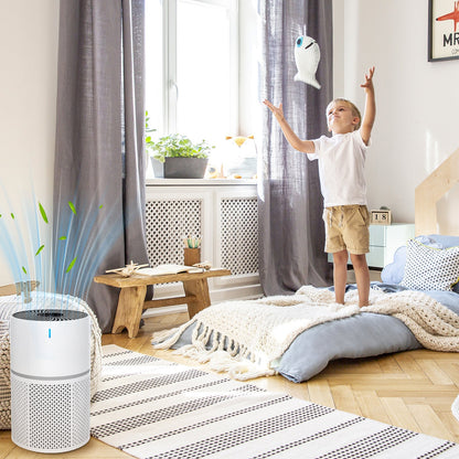 Child playing with a toy in a room with an Klarity Air Purifier on the floor.