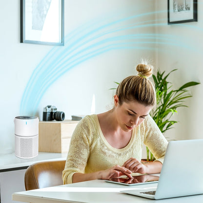 Woman using a laptop with an Klarity Air Purifier in the background