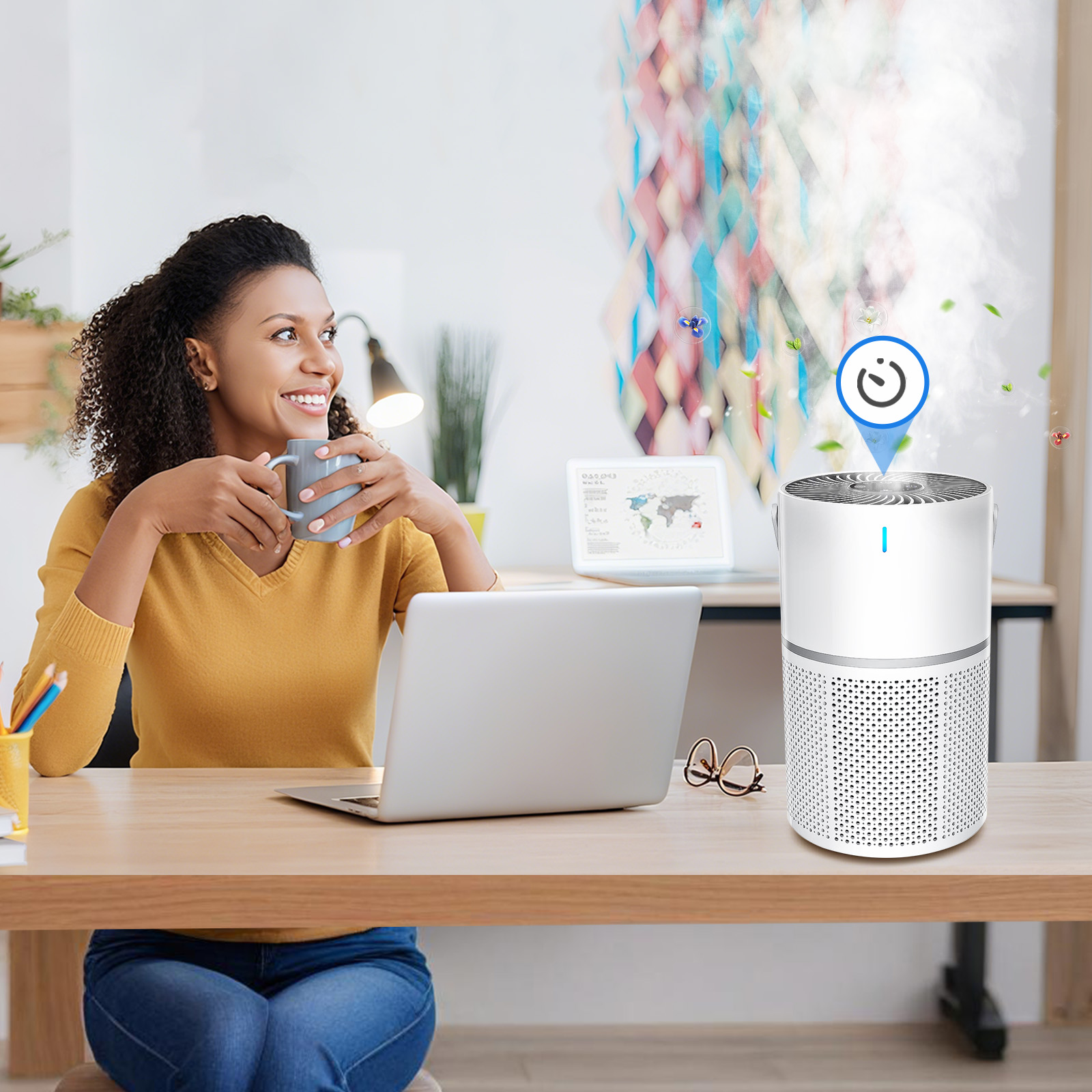 Woman sitting at a desk with a laptop and Klarity Air Purifier, holding a mug.