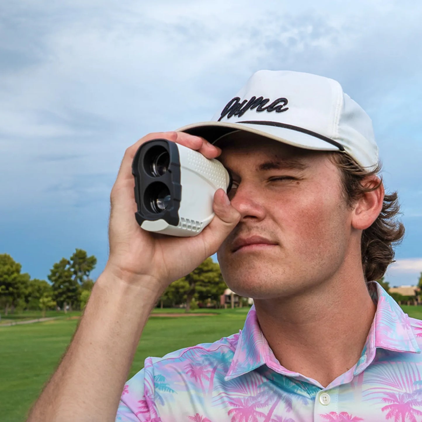 Man using a Klarity Golf Rangefinder on a golf course